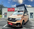 Copper Bronze Campervan with Poptop roof parked in front of CamperKing Scotland showroom