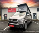 Mojave Beige Campervan parked in front of CamperKing Scotland Showroom with the pop top roof up.